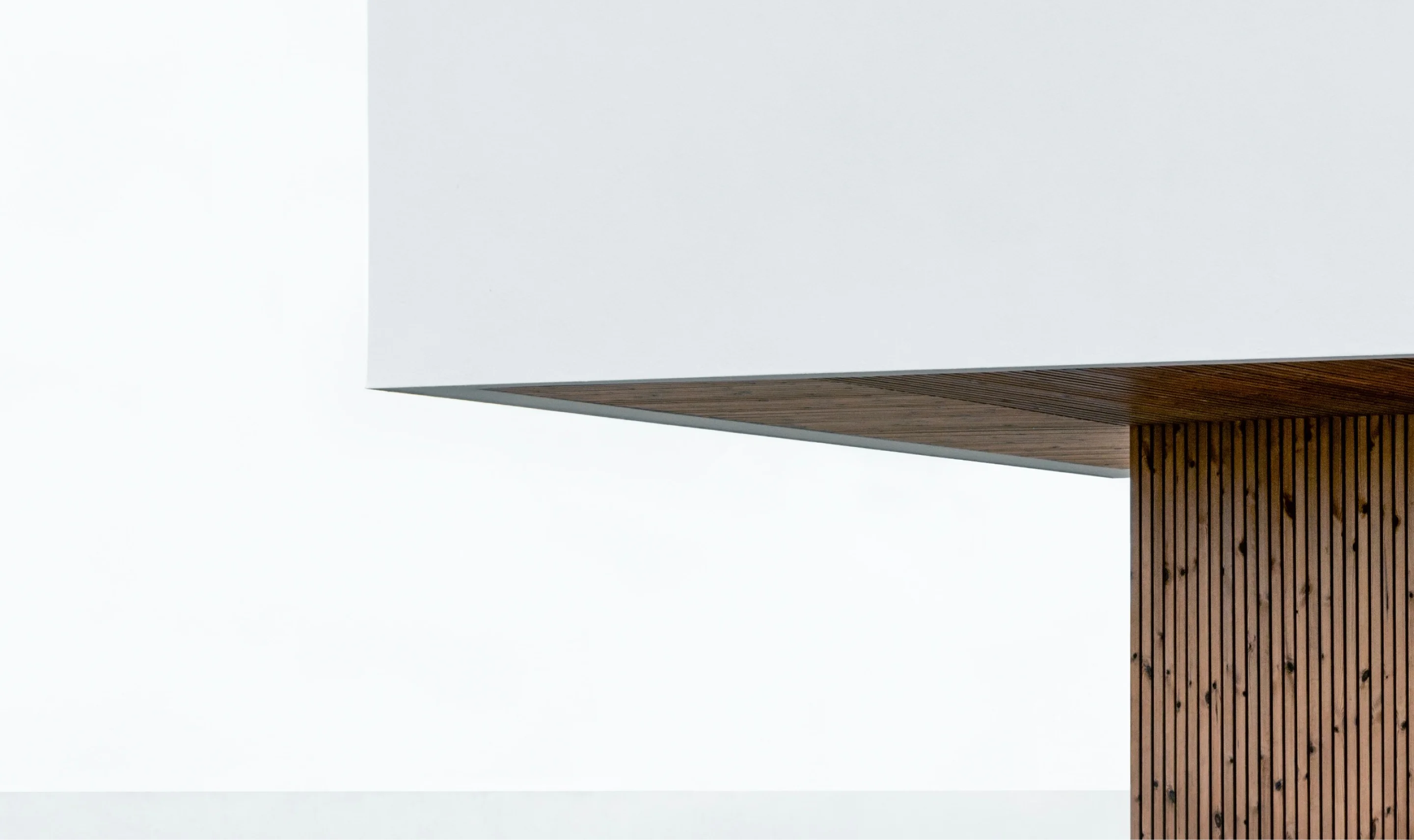 A white wall with a wooden panel, adding warmth and texture to the space.